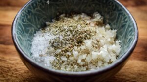 Bowl of salt, spices, and seasonings mixed for leberkäse on a wooden surface