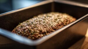 Seasoned leberkäse meat loaf shaped inside a rectangular baking pan
